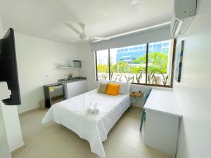 1 dormitorio con cama blanca y ventana en Magico Apartaestudio con Piscina 1 Habitacion PR29 en Montería