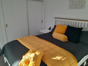 a bedroom with a large bed with yellow and blue at Saffron Cottage in Cromwell