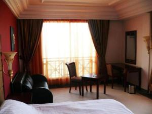 een slaapkamer met een bed, een bureau en een raam bij Hôtel César Palace in Sousse