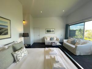 un soggiorno con un grande letto e un divano di Delamore Cove - Karaka - Waiheke Escapes a Matiatia Bay