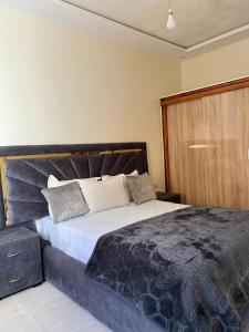 um quarto com uma cama grande e uma porta de madeira em camping atlantique tan tan em Tan-Tan Plage