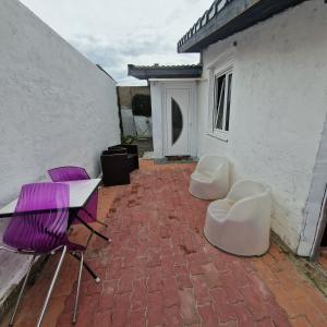 un patio con tavolo e sedie viola e bianca. di maison Samkam57 a Florange