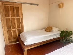 Una cama en una habitación con un gato sentado en ella en Casa Costa Salvaje, en El Gigante
