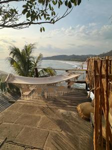 a hammock on a beach next to the water at Casa Costa Salvaje in El Gigante
