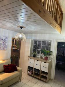 un soggiorno con divano e lampadario pendente di Palmhouse Apartments Aruba 1- 4 persons a Savaneta