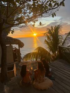 three girls sitting on a deck watching the sunset at Casa Costa Salvaje in El Gigante
