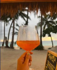 a person holding up a glass of beer at Boracay Luxury Apartments in Boracay