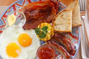 a plate of breakfast food with eggs bacon and toast at Boracay Luxury Apartments in Boracay