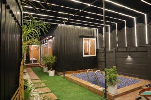 een zwart huis met een zwembad en planten bij BlackWood Inn Farm Stay in Mohāna