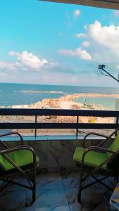 een balkon met 2 stoelen en uitzicht op het strand bij شقه للايجار عالبحر مباشره in Alexandrië