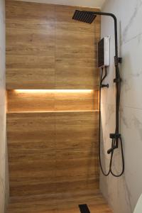 a shower in a bathroom with a wooden wall at Boracay Luxury Apartments in Boracay +37 photos