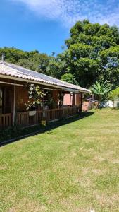 uma casa com uma cerca e um jardim de relva em chácara São Jose dos Pinhais em São José dos Pinhais