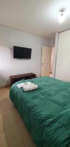 sypialnia z zielonym łóżkiem i 2 ręcznikami w obiekcie La Casita de DaniMar w mieście Yerba Buena
