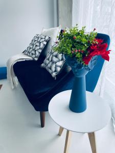 un canapé bleu et une table avec un vase et des fleurs dans l'établissement Partenope Hostel and Suites, à Angra do Heroísmo