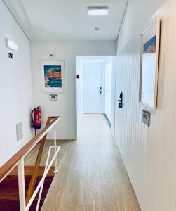 a hallway with white walls and a white door at Partenope Hostel and Suites in Angra do Heroísmo