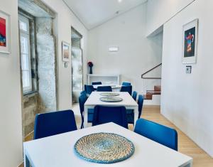 a dining room with white tables and blue chairs at Partenope Hostel and Suites in Angra do Heroísmo