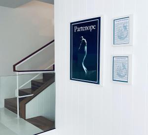 a picture of a woman on a poster on a wall next to a staircase at Partenope Hostel and Suites in Angra do Heroísmo