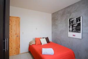 ein Schlafzimmer mit einem roten Bett in einem Zimmer in der Unterkunft Planta Alta in Ensenada