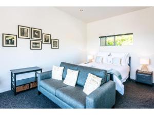 une chambre avec un lit et un canapé dans l'établissement Delamore Cove - Kauri - Stay Waiheke, à Matiatia Bay