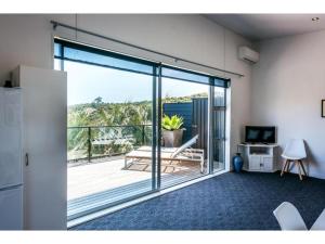 une chambre avec une porte coulissante en verre avec un balcon dans l'établissement Delamore Cove - Kauri - Stay Waiheke, à Matiatia Bay