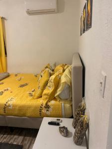 a bed with a yellow comforter in a room at Room in Apartment - Bahamas petapat suite in Nassau