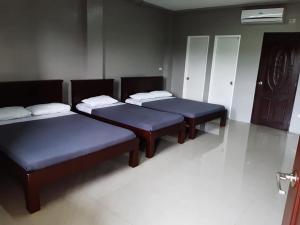 a group of three beds in a room at EL SEÑOR JESUS APARTELLE in Ayusan Norte