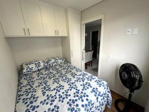 a bedroom with a blue and white bed and a fan at Apto Moderno e Acolhedor in Sao Paulo
