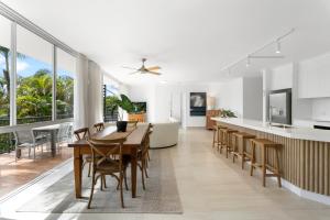 a kitchen and dining room with a table and chairs at Noosa Tropicana in Noosaville