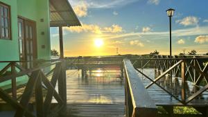 a wooden walkway with a sunset in the background at Loft Serra Chalés in Serra de São Bento
