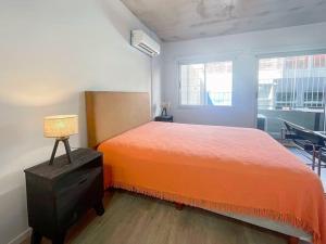 布宜諾斯艾利斯的住宿－Estudio en La Boca-Confort y Encanto-Filiberto，一间卧室配有橙色的床和窗户。