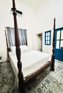 ein Schlafzimmer mit einem Bett mit einem Holzrahmen in der Unterkunft The Vintage villa in Diriamba