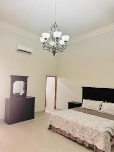 1 dormitorio con cama y lámpara de araña en The Vintage villa, en Diriamba