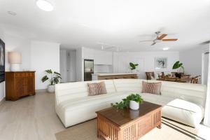 a living room with a white couch and a table at Noosa Tropicana in Noosaville