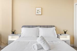 Un dormitorio blanco con una cama con toallas. en Luxury High Rise 1BD River Views Downtown Pittsburgh, en Pittsburgh