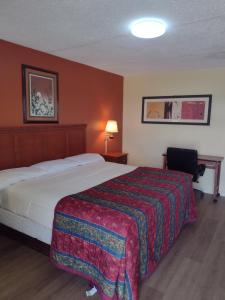 ein Hotelzimmer mit einem Bett und einem Stuhl in der Unterkunft Rolling Fork Motel 