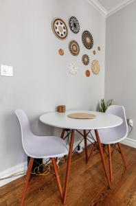 een tafel en twee stoelen en een tafel en borden aan de muur bij Room at the heart of East Village 1 in New York