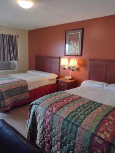 ein Hotelzimmer mit 2 Betten und 2 Lampen in der Unterkunft Rolling Fork Motel 