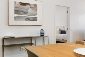 uma sala de estar com uma mesa e uma imagem na parede em Hobson Quay Apartments by Urban Rest em Auckland mais 11 fotografias