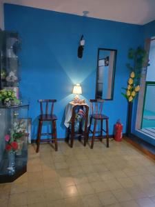 a blue room with two chairs and a table with a lamp at Hotel Trianon in San José