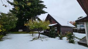 ein Haus mit Schnee vor einem Haus in der Unterkunft Entre montañas in San Carlos de Bariloche