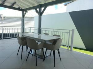 a white table and chairs on a balcony at Villa Gosier COSY LOFT JACUZZI - T3 in Le Gosier