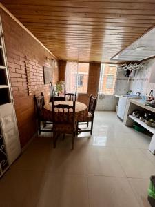 a dining room with a table and chairs in a kitchen at El pinar, Dindalito in Bogotá