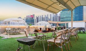 a patio with a table and chairs with a view of a city at Dongdaegu Station Eastern Hotel in Daegu