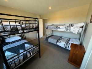 a room with three bunk beds in a room at 7a Coleridge Street in Hanmer Springs