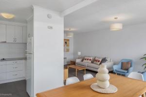 Una cocina y una sala de estar con mesa y sillas. en Sandy Bay Waterfront, en Sandy Bay