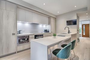 a kitchen with a large white counter and chairs at Luxury Townhouse in Downtown Toronto - TH4 in Toronto