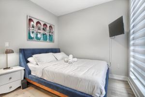 a bedroom with a blue bed and a tv at Luxury Townhouse in Downtown Toronto - TH4 in Toronto