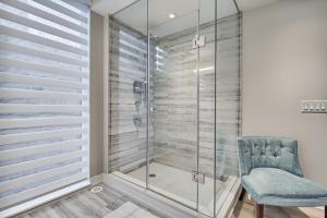 a glass shower with a blue chair in a bathroom at Luxury Townhouse in Downtown Toronto - TH4 in Toronto