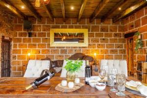 a dining room with a table and a brick wall at Quinta María Victoria in Bernal