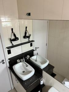 a bathroom with a sink and a mirror at Camboriu ao Nascer do Sol in Camboriú